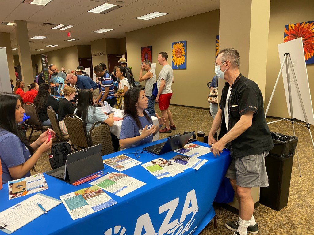 Nia Uhlenhake answers autism-related questions from an attendee at the AZA United booth located at the 7th Annual Autism Expo.